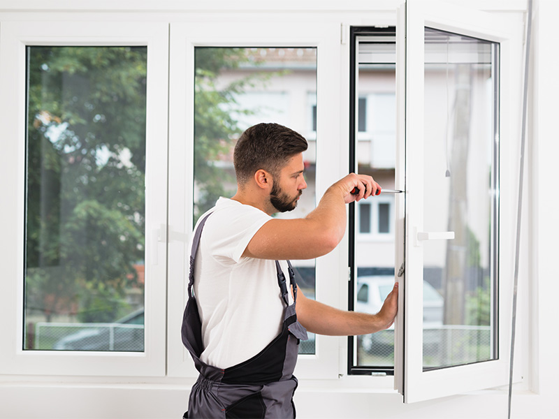 Handwerker montiert PVC-Fenster im Innenraum, moderne Technik, präzise Arbeit.