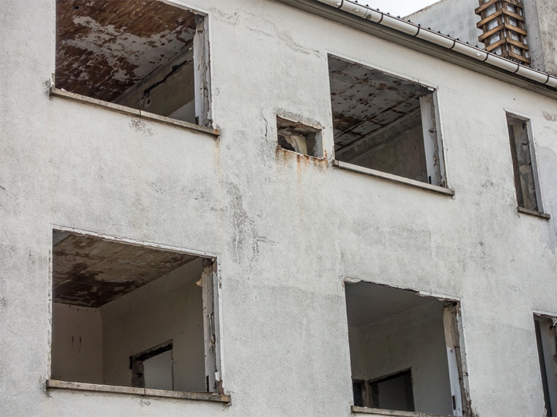 Gebäudeentkernung an einem Industriegebäude mit Baggerarbeiten, freigelegten Stahlträgern und vorbereiteten Rückbauflächen für Sanierungsmaßnahmen.