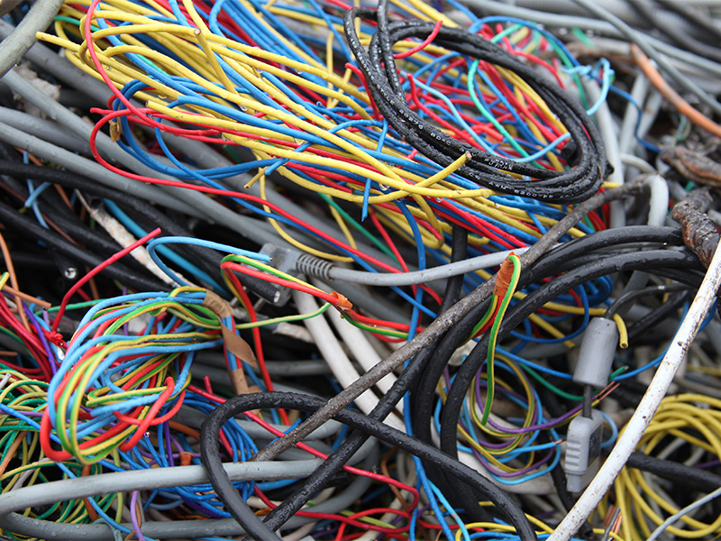 Kabelschrott in chaotischem Haufen – isolierte Drähte verschiedener Farben und Stärken sichtbar.