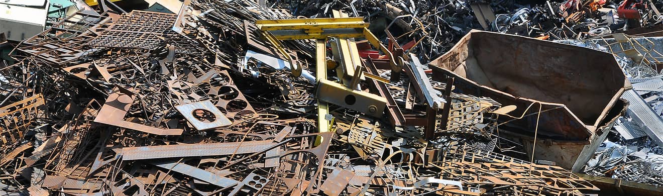 Ein großer Schrotthaufen mit Metallteilen liegt im Freien – Schrottentsorgung von Schrotthandel in Ratzeburg.