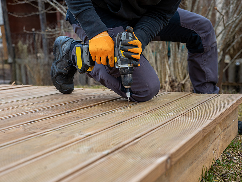 Handwerker montiert imprägnierte Holzdielen auf einer Terrasse – professioneller Holzterrassenbau in Schwarzenbek.