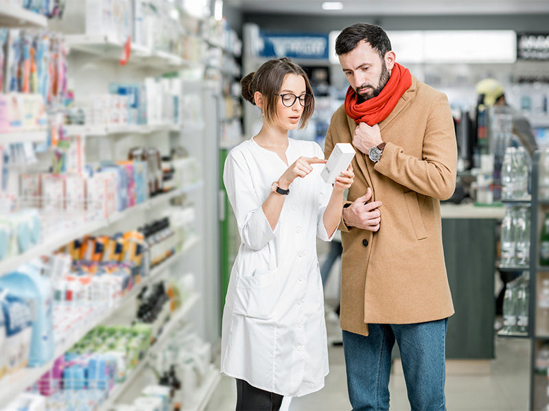 Apothekerin berät Kunde in der Apotheke beim Wechselwirkungs Check seiner Medikamente − professionell und vertrauensvoll.“